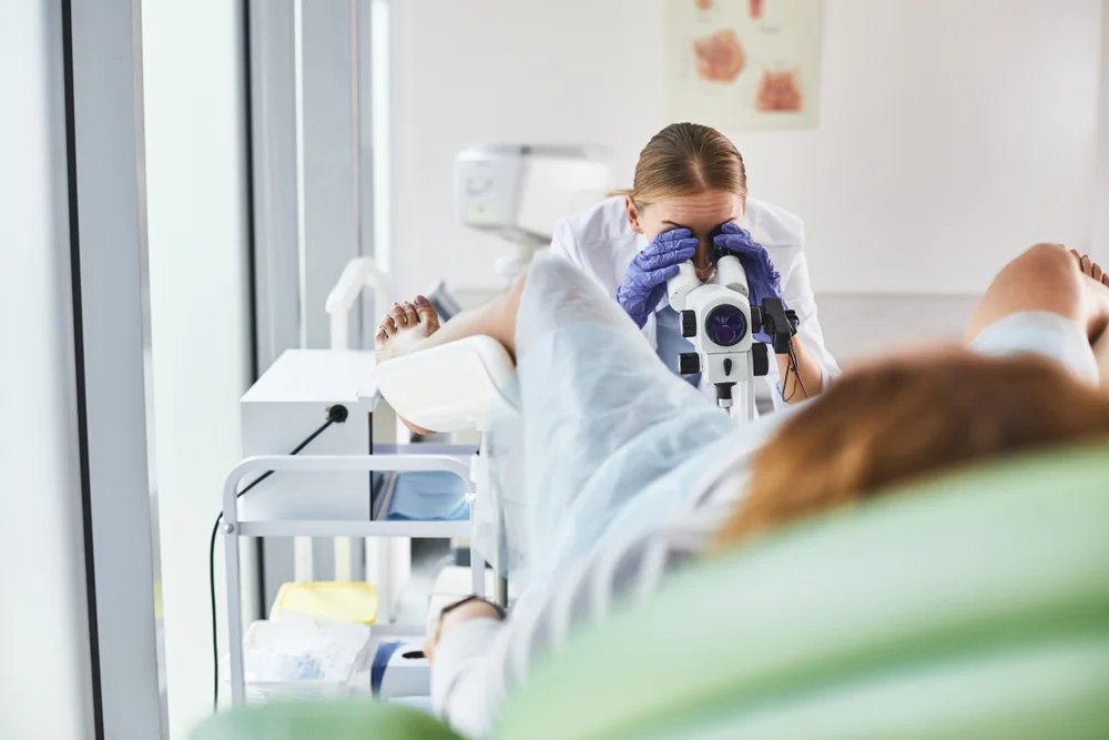 Médica realizando exame ginecologico em paciente.