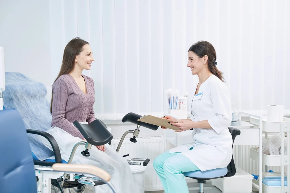 Médica ginecologista atendendo paciente mulher.