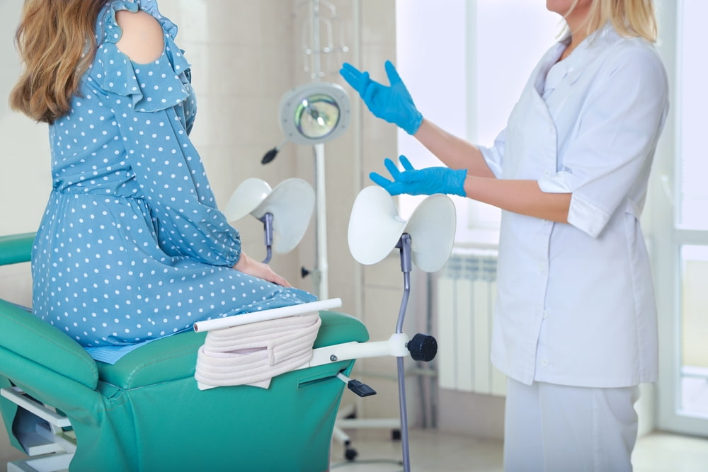 Médica ginecologista atendendo paciente mulher.