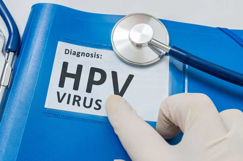 Mão com luva apontando para Pasta com adesivo de HPV
