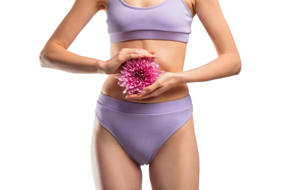 Mulher de roupas íntimas segurando flor