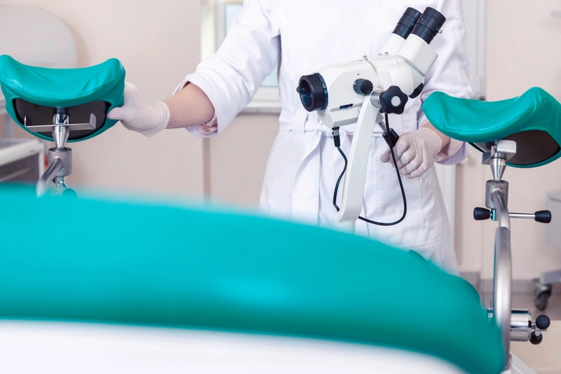 Profissional médica em sala de exames ginecológicos.