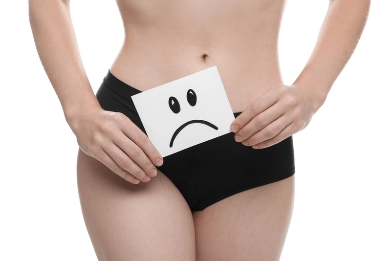 Mulher de roupa íntima segurando placa de cara triste