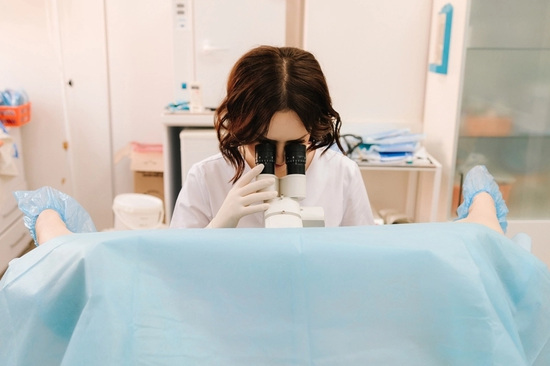 Médica ginecologista realizando biópsia de vulva em paciente