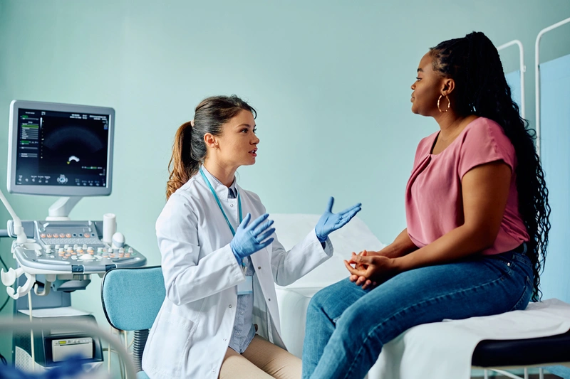 Médica ginecologista explicando para paciente mulher sobre riscos do líquen não tratado