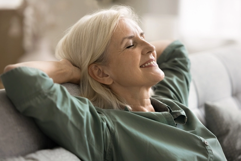 Mulher feliz e sorridente sentada em sofá